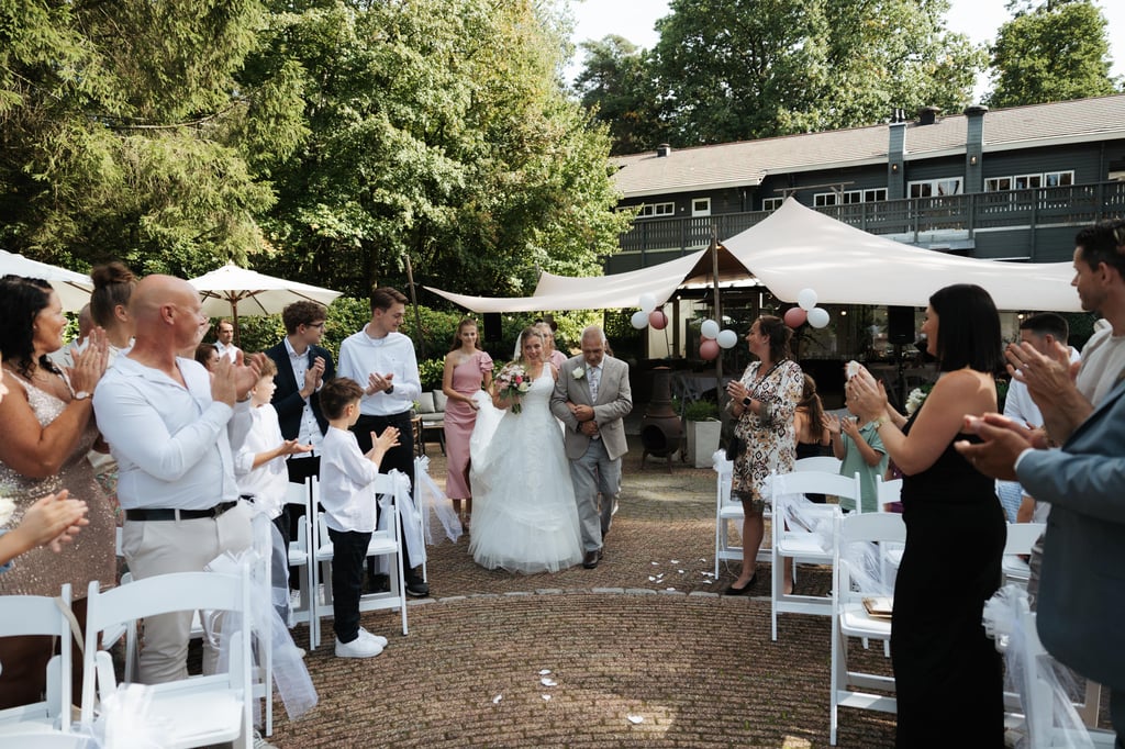 Bruid wordt naar het altaar begeleid