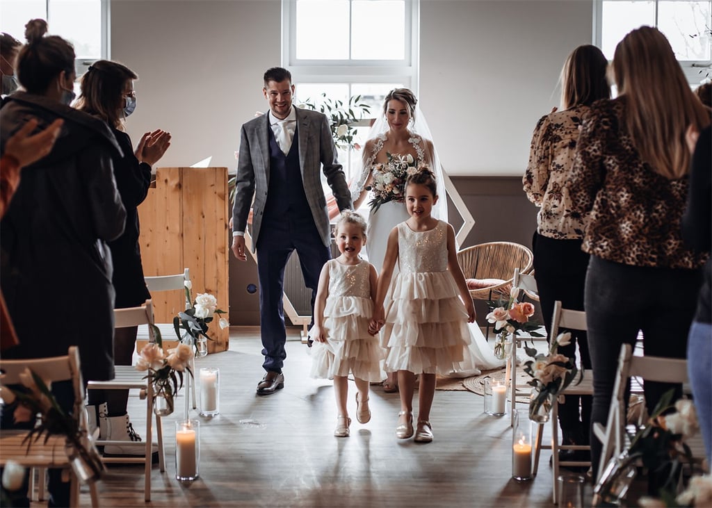 Het bruidspaar en bruidsmeisjes lopen door de ceremonie