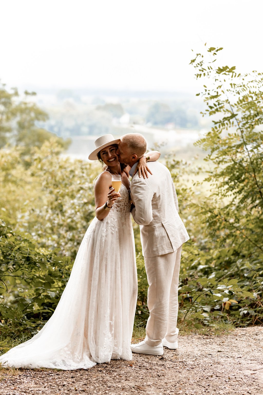 Bruidspaar proost met uitzicht over de natuur