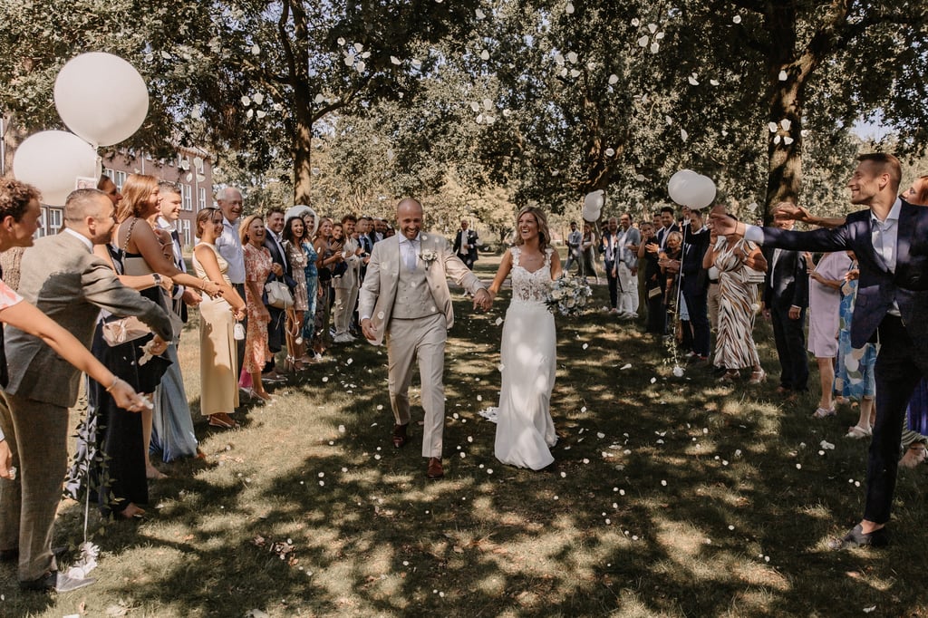 Bruidspaar loopt door bloemenregen na de ceremonie